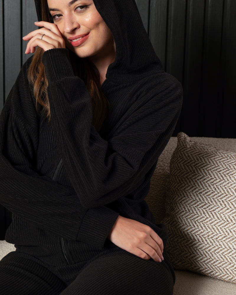 تفاصيل خامة البيجامة القطيفة الريب المضلعة باللون الأسود، مع كابيتشو وتصميم أنيق من PYJAMODA.